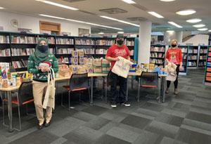 Three workers from the Fit, Fed and Read programme in a Redbridge library