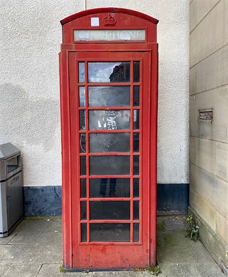 A traditional red telephone box in disrepair 