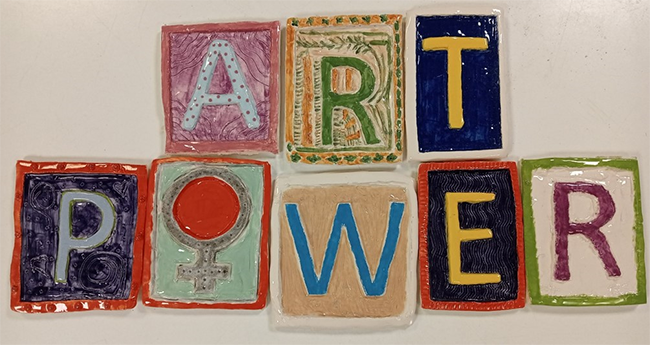 Colourful hand-made tiles spelling Art Power. 