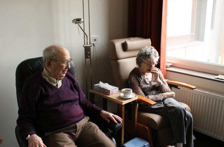 Elderly couple sitting beside each other in hospital