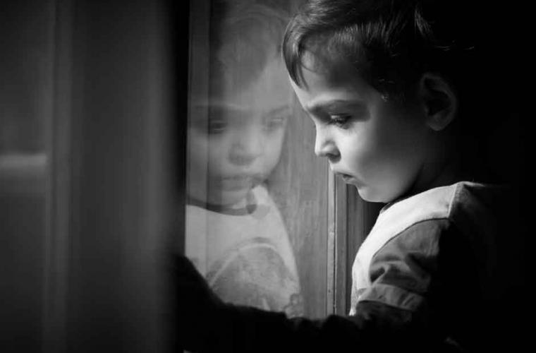 Young boy looking out of a window 