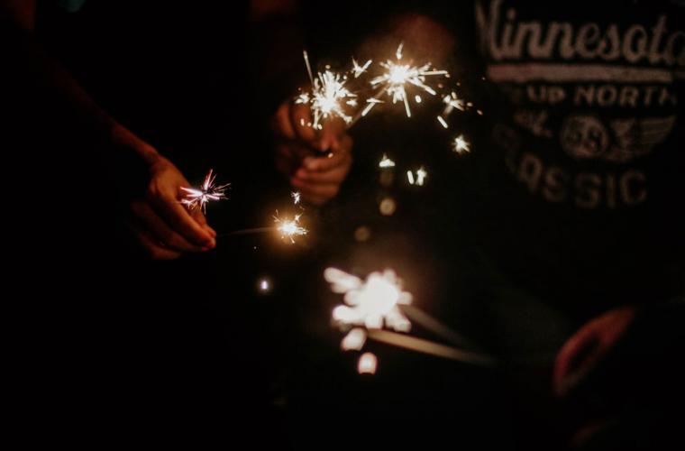 People holding sparklers at night