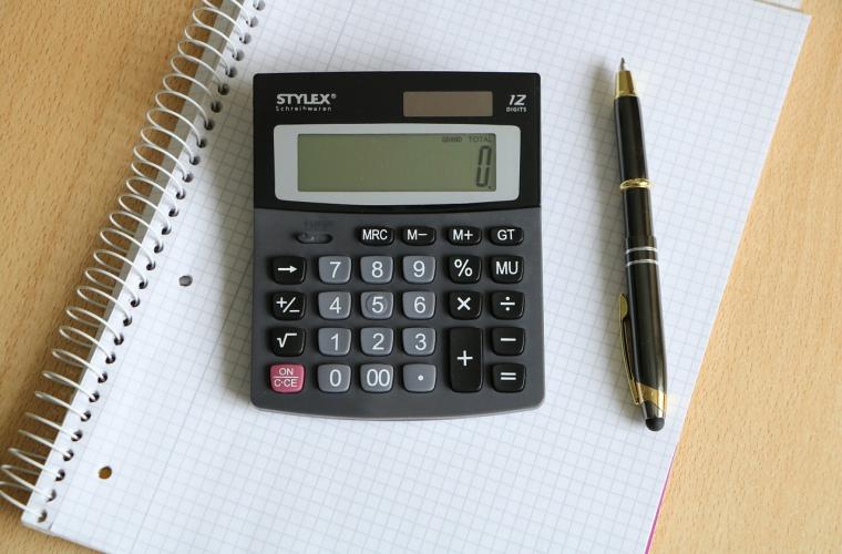Calculator and pen resting on a notepad