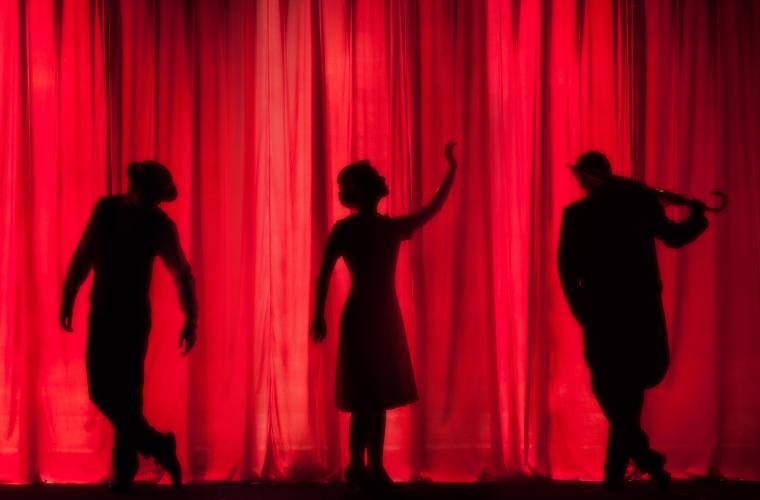 Three silhouettes on stage
