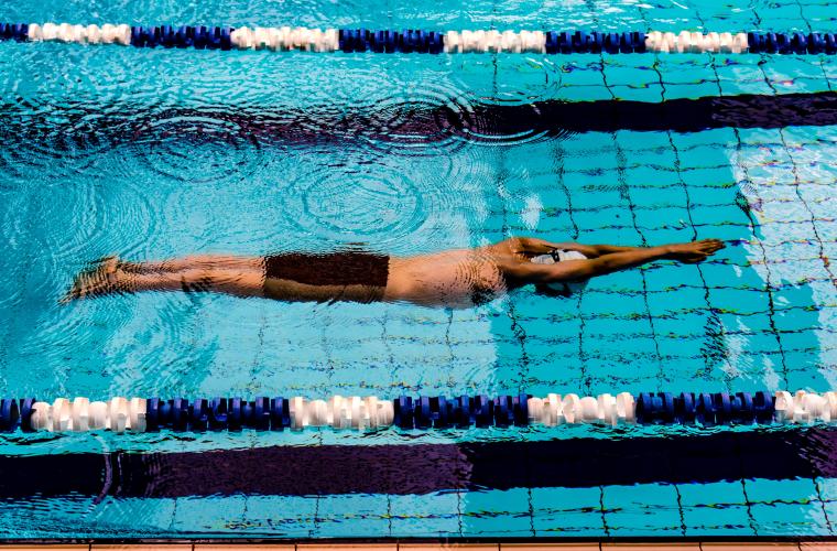 man swimming in indoor pool