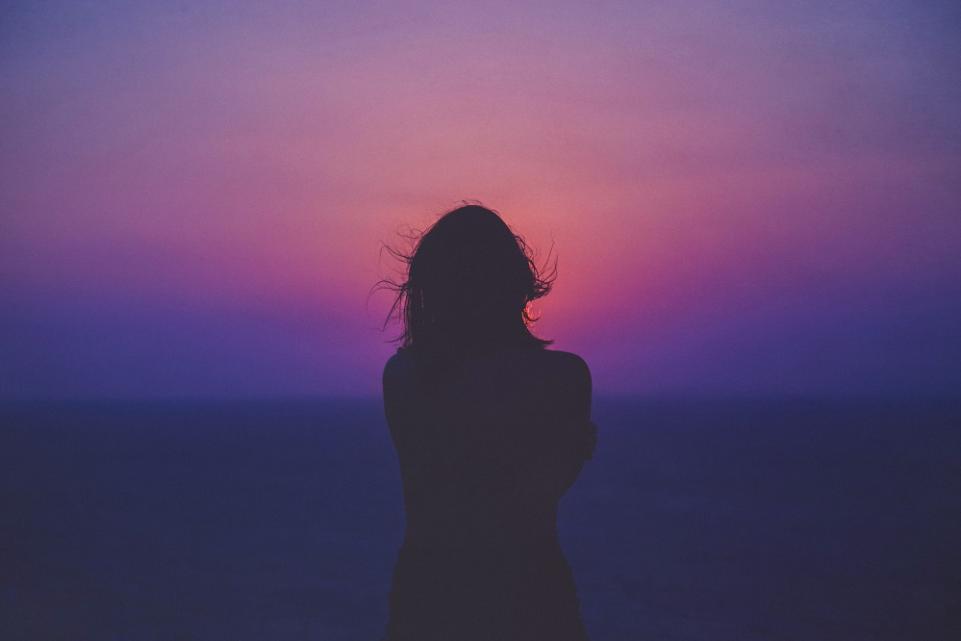 Silhouette of a young woman at sunset